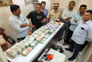Police officials with the seized cash in Chhatrapati Sambhajingar in Maharashtra on Saturday night