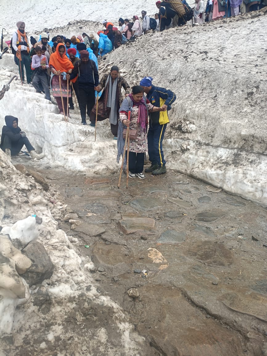 SDRF personnel helping pilgrims cross the glacier