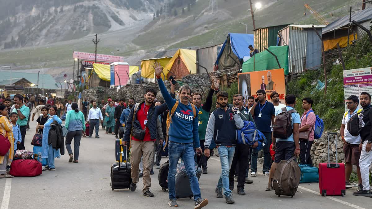 Pilgrims raise slogans as they are on their way to Amarnath Cave for the Amarnath Yatra, in Baltal on Wednesday.