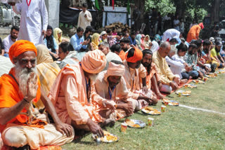 Devotees from the Amarnath Yatra eat langar organized by the head priest of the Chhari Mubarak custodian Mahant Deependra Giri, in Pahalgam on July 22.