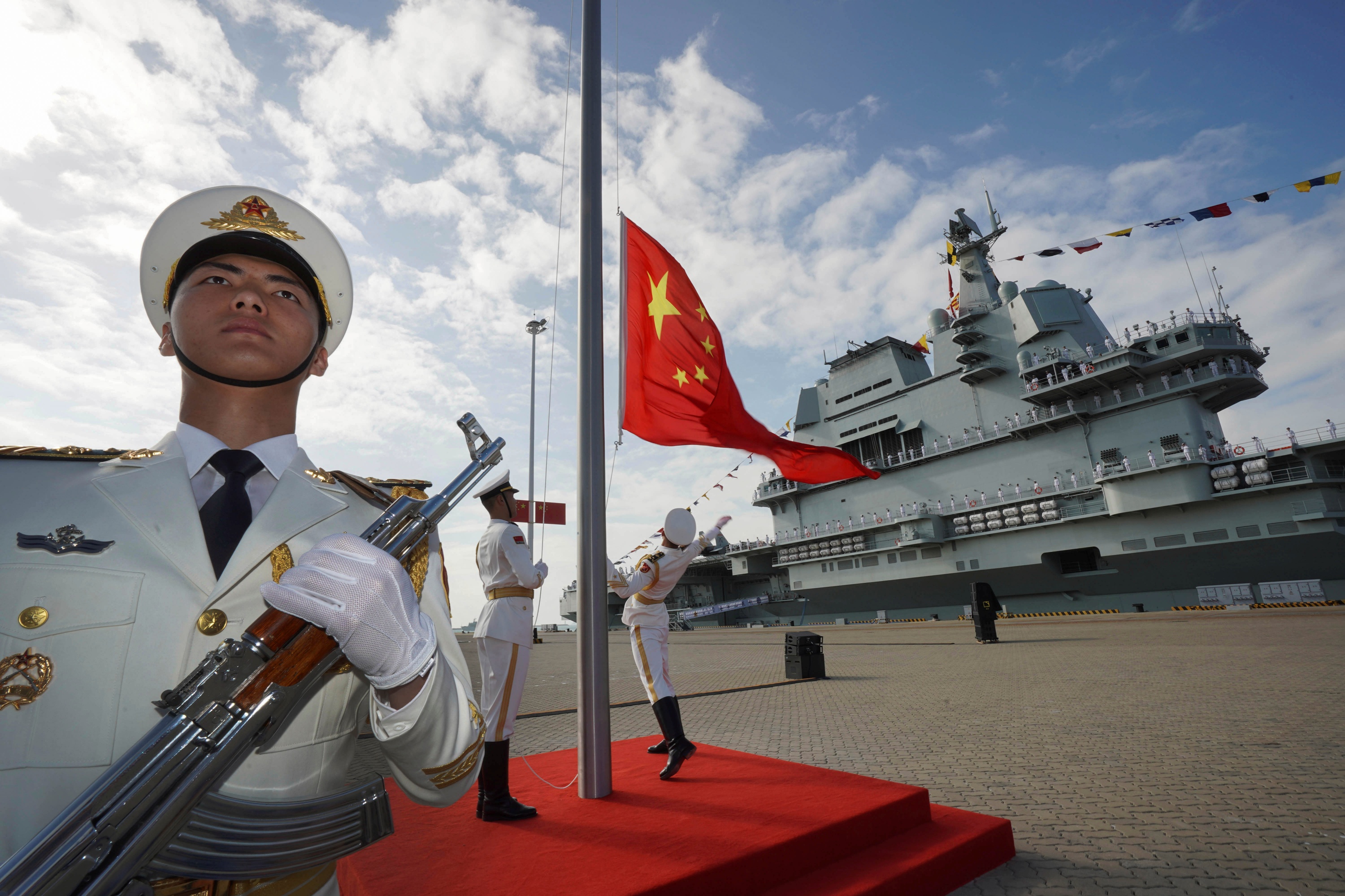 Chinese honor guard raise the Chinese flag during the commissioning ceremony of China's conventionally powered Shandong aircraft carrier at a naval port in Sanya, south China's Hainan Province, on Dec. 17, 2019.