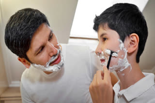 Father teaching his young son to shave