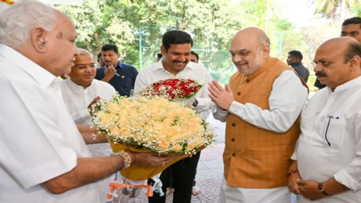 Amit Shah first received bouquet from Vijayendra instead of BSY  ബിവൈ വിജയേന്ദ്ര  Amit Shah first received bouquet from Vijayendra  Vijayendra son of BSY  യെദ്യൂരപ്പ  ബൊക്കെ ചര്‍ച്ചയില്‍ കര്‍ണാടക