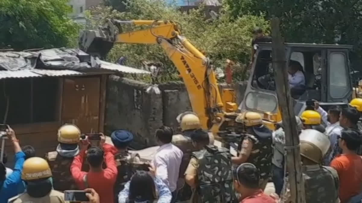 A bulldozer razing structures in Uttarakhand's Lalkuan railway land
