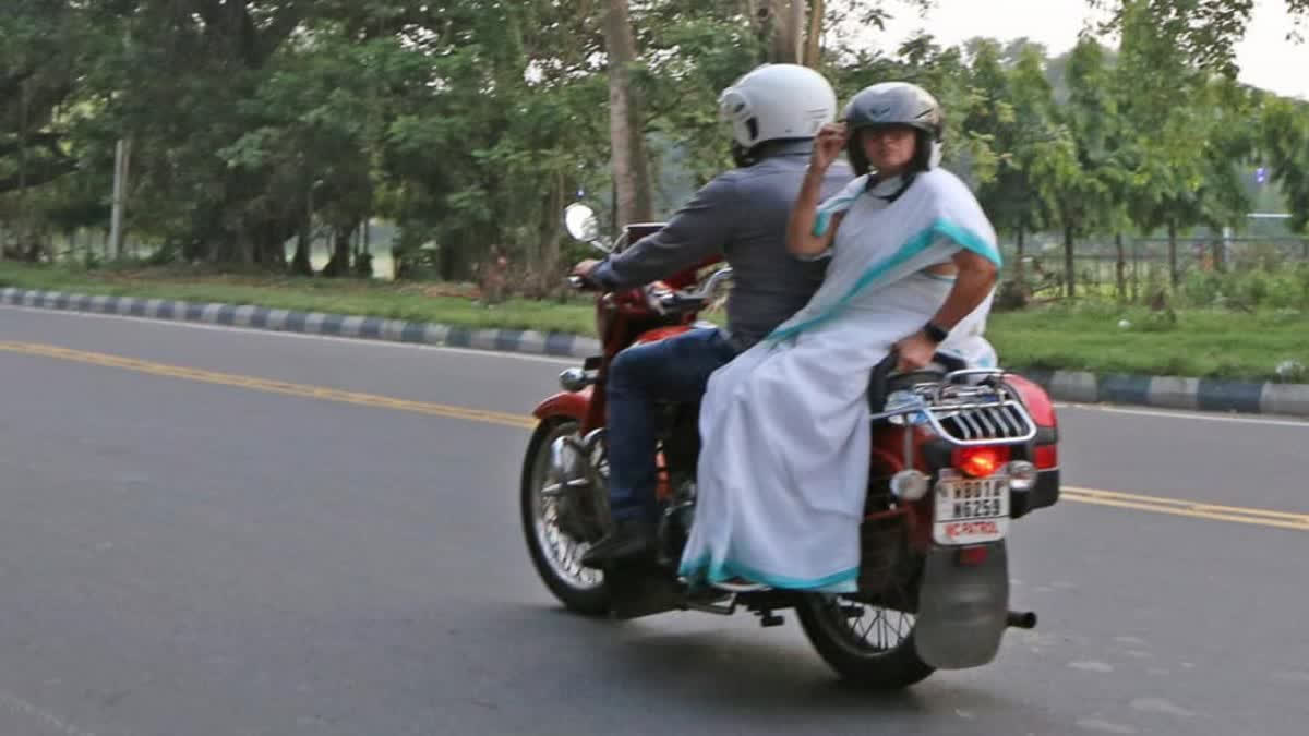 cm mamta banerjee shows her humanitarian  her car for sick photojournalist  wrestler protest in delhi  ಕಾರು ಕೊಟ್ಟು ಬೈಕ್​ನಲ್ಲಿ ತೆರಳಿದ ಸಿಎಂ ಮಮತಾ  ಕಾರ್ಯಕ್ರಮದಲ್ಲಿ ಅಸ್ವಸ್ಥಗೊಂಡ ಪತ್ರಕರ್ತೆ  ಪಶ್ಚಿಮ ಬಂಗಾಳದ ಮುಖ್ಯಮಂತ್ರಿ ಮಮತಾ ಬ್ಯಾನರ್ಜಿ  ಗುರುವಾರ ಬೈಕ್‌ನಲ್ಲಿ ಹೋಗುತ್ತಿರುವುದು ಕಂಡು ಬಂತು  ಮಾನವೀಯ ಮುಖ ಮತ್ತೊಮ್ಮೆ  ಕಾರ್ಯಕ್ರಮದಲ್ಲಿ ಅಸ್ವಸ್ಥಗೊಂಡ ಮಹಿಳಾ ಪತ್ರಕರ್ತ  ಕುಸ್ತಿಪಟುಗಳನ್ನು ಬೆಂಬಲಿಸಿ ಮಮತಾ ಬ್ಯಾನರ್ಜಿ  ಮಮತಾ ಬ್ಯಾನರ್ಜಿ ಅವರ ಭದ್ರತಾ ಸಿಬ್ಬಂದಿ