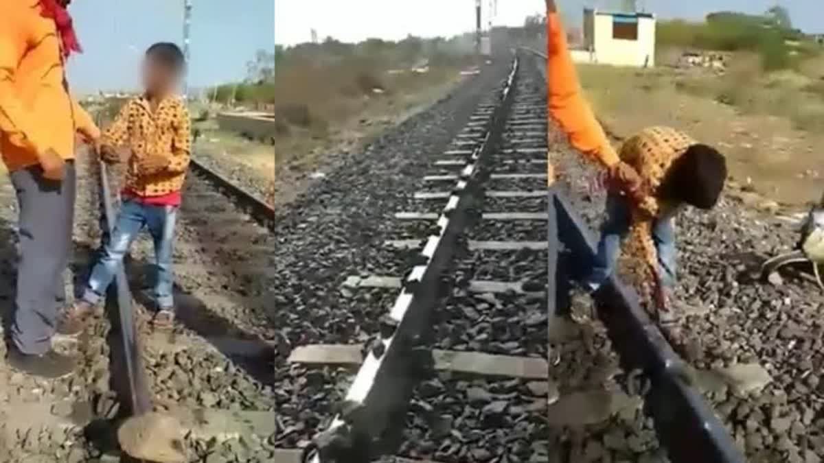 child placing stone on railway track