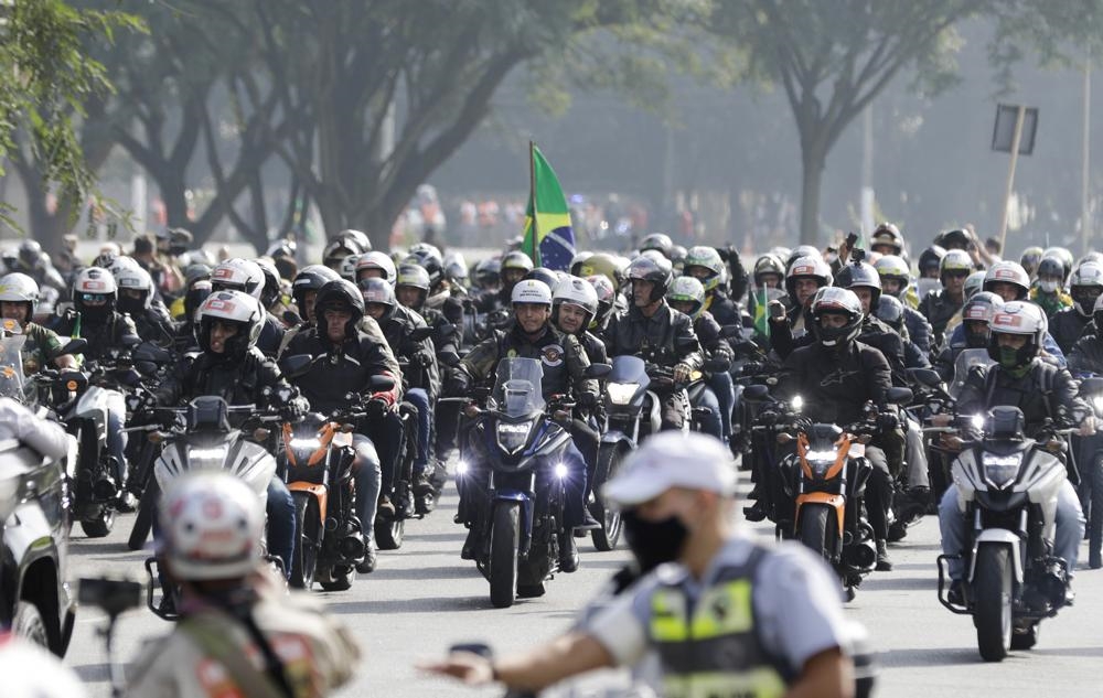 Brazil's President Jair Bolsonaro, center, takes part in a caravan of motorcycle during rally