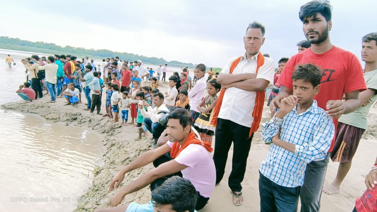 किनारे आस लगाए बैठे लोग.