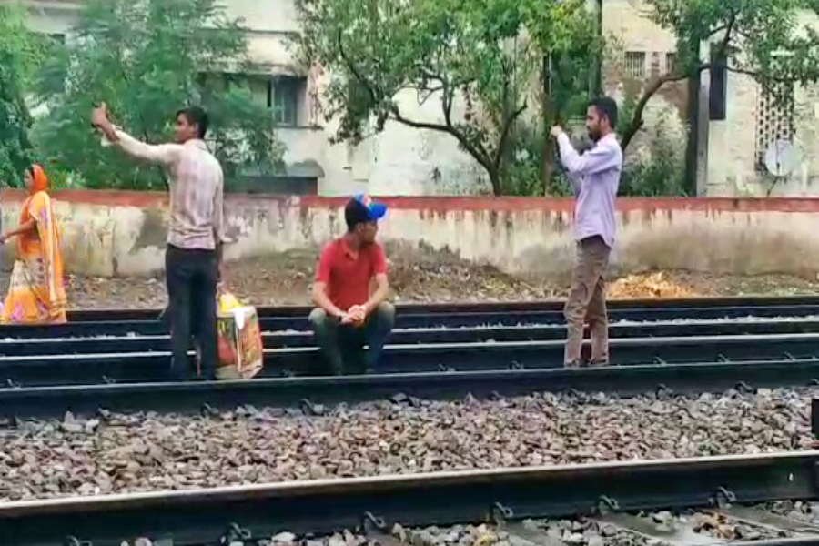 people taking selfie railway crossing