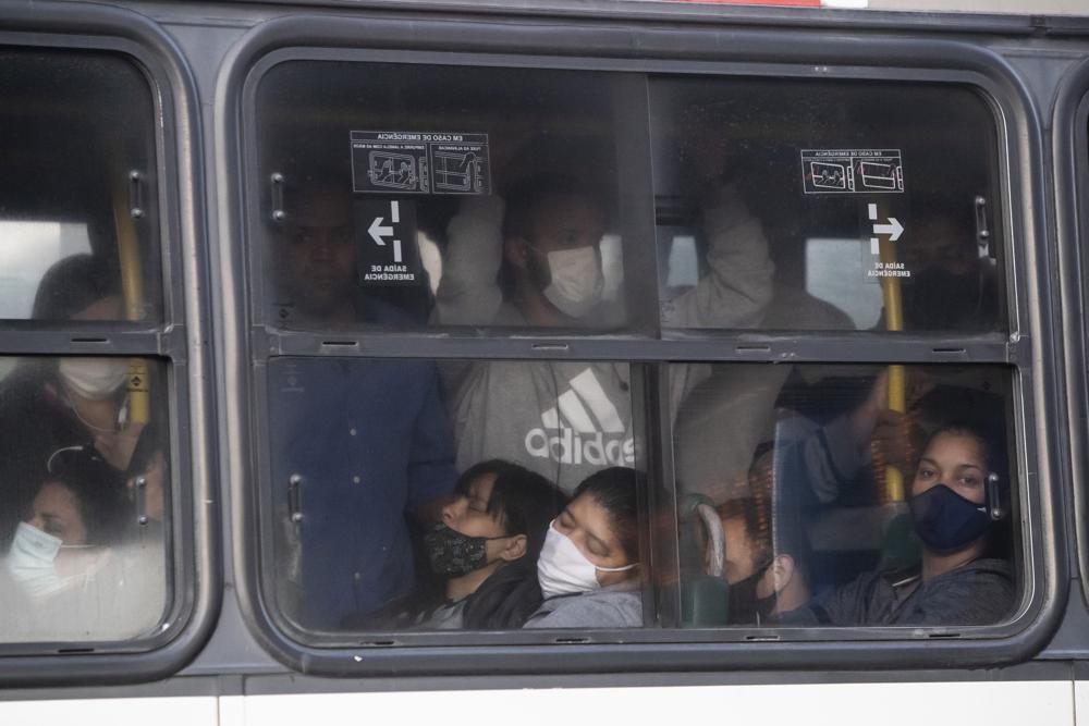 Commuters crowd a bus during the COVID-19 pandemic in Rio de Janeiro, Brazil, Friday, July 23, 2021. (AP Photo/Bruna Prado)