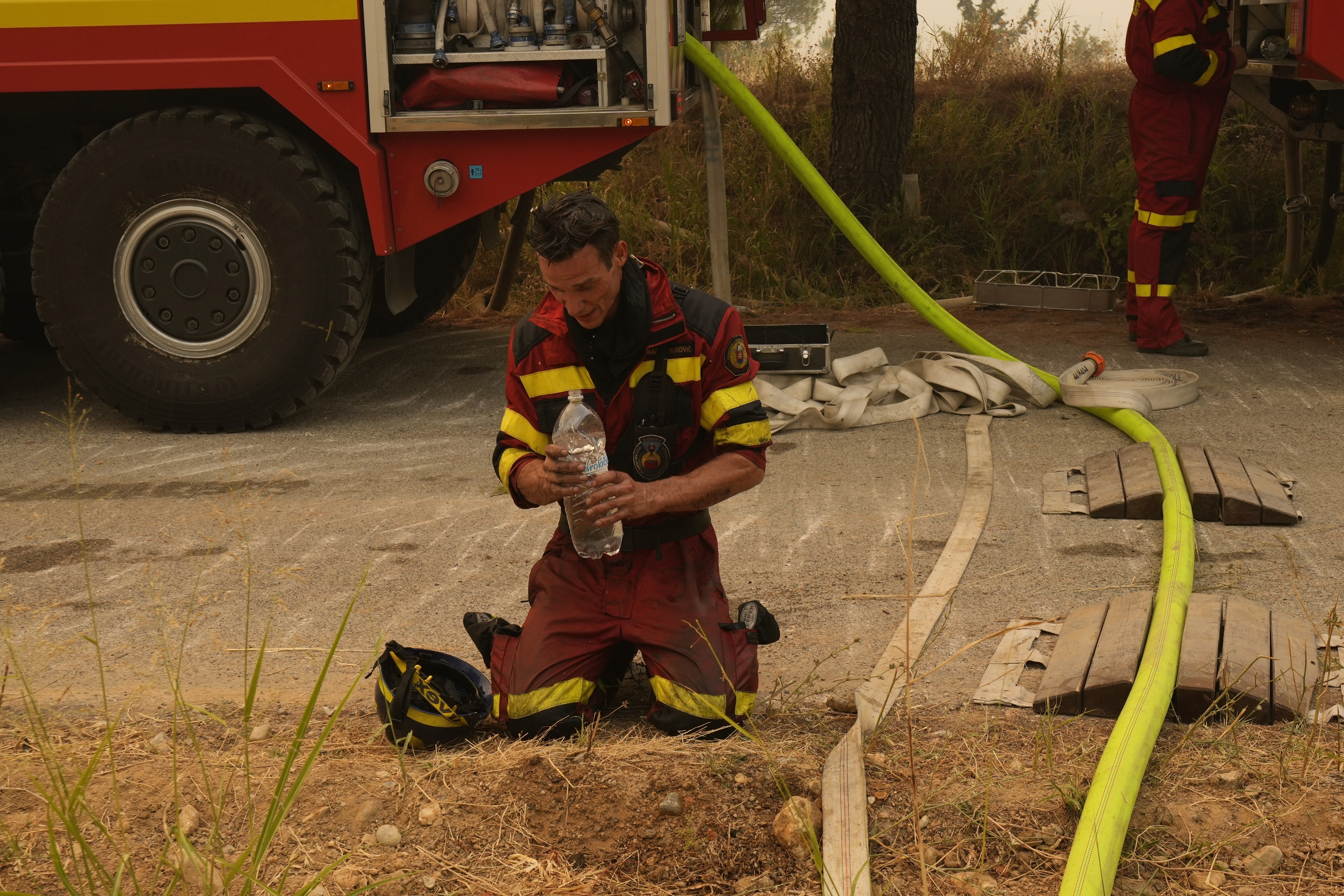 A firefighter from Slovakia cools himself down during a wildfire in Avgaria