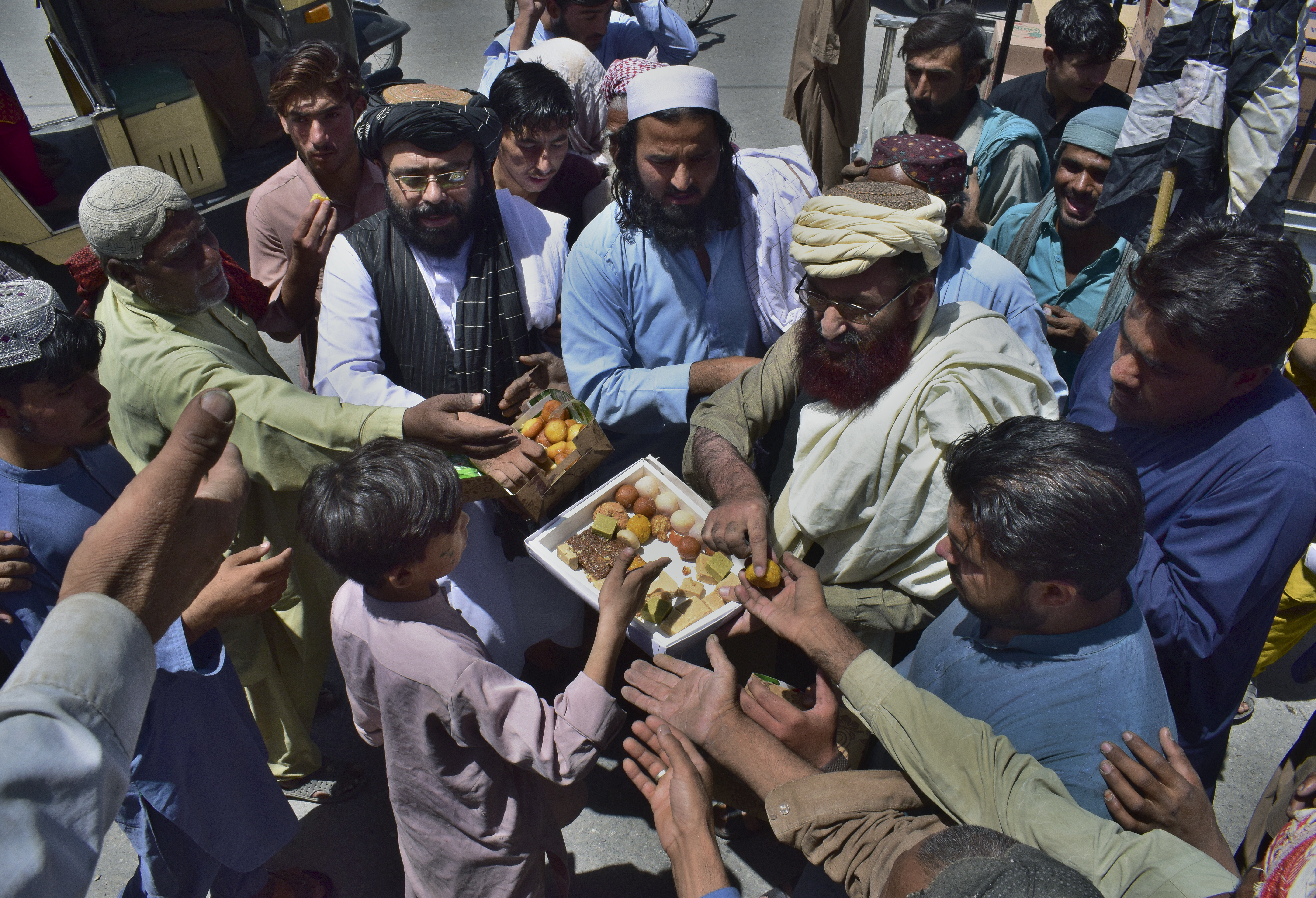 Leaders of the Pakistani religious group Jamiat Ulema-e Islam Nazryate party distribute sweets