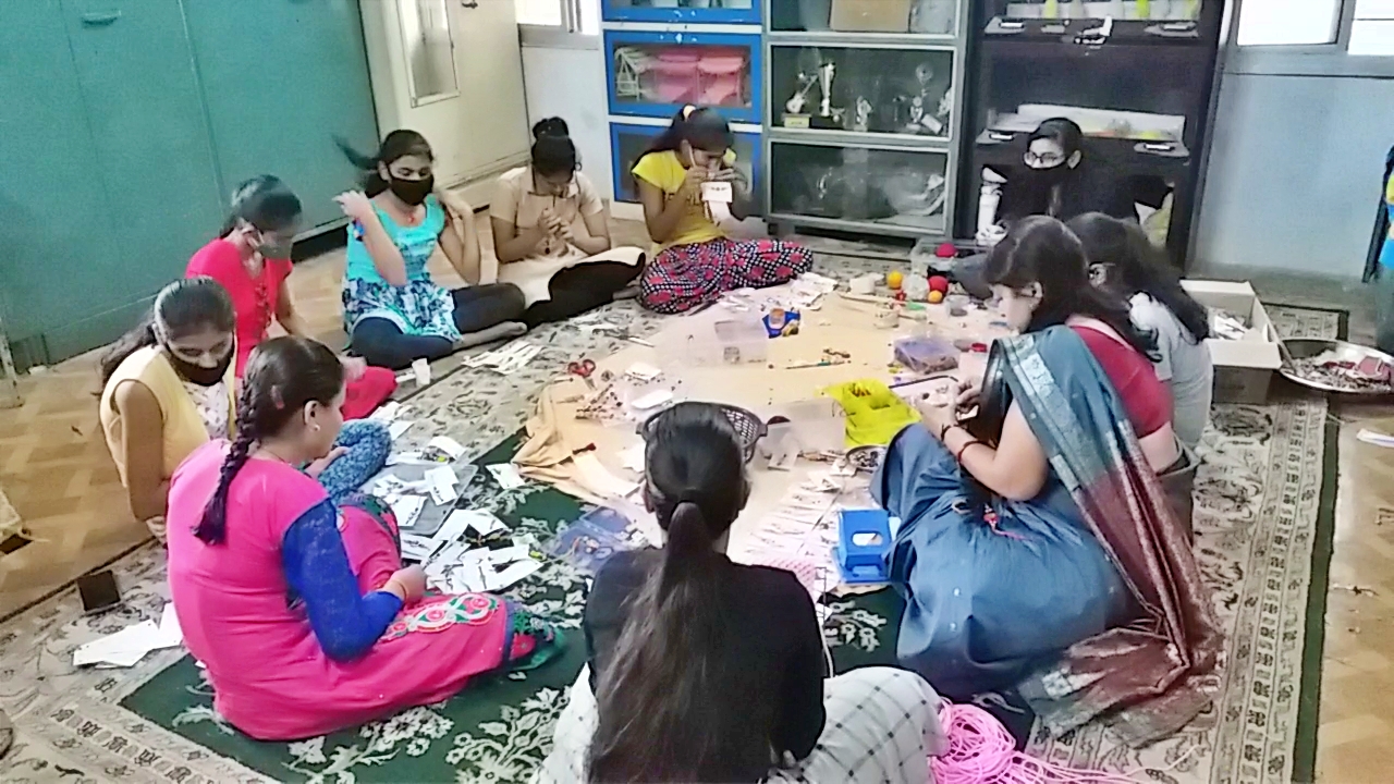 Girls making rakhis sitting in group