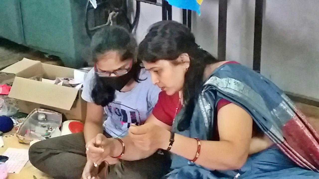 Craft teacher teaching girls to make Rakhi