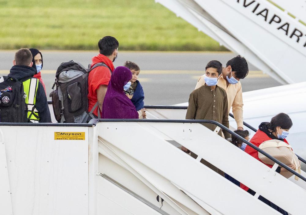 People disembark from an Air Belgium chartered plane, carrying passengers as part of an evacuation from Afghanistan, upon arrival at Melsbroek Military Airport in Melsbroek, Belgium, Friday, Aug. 27, 2021