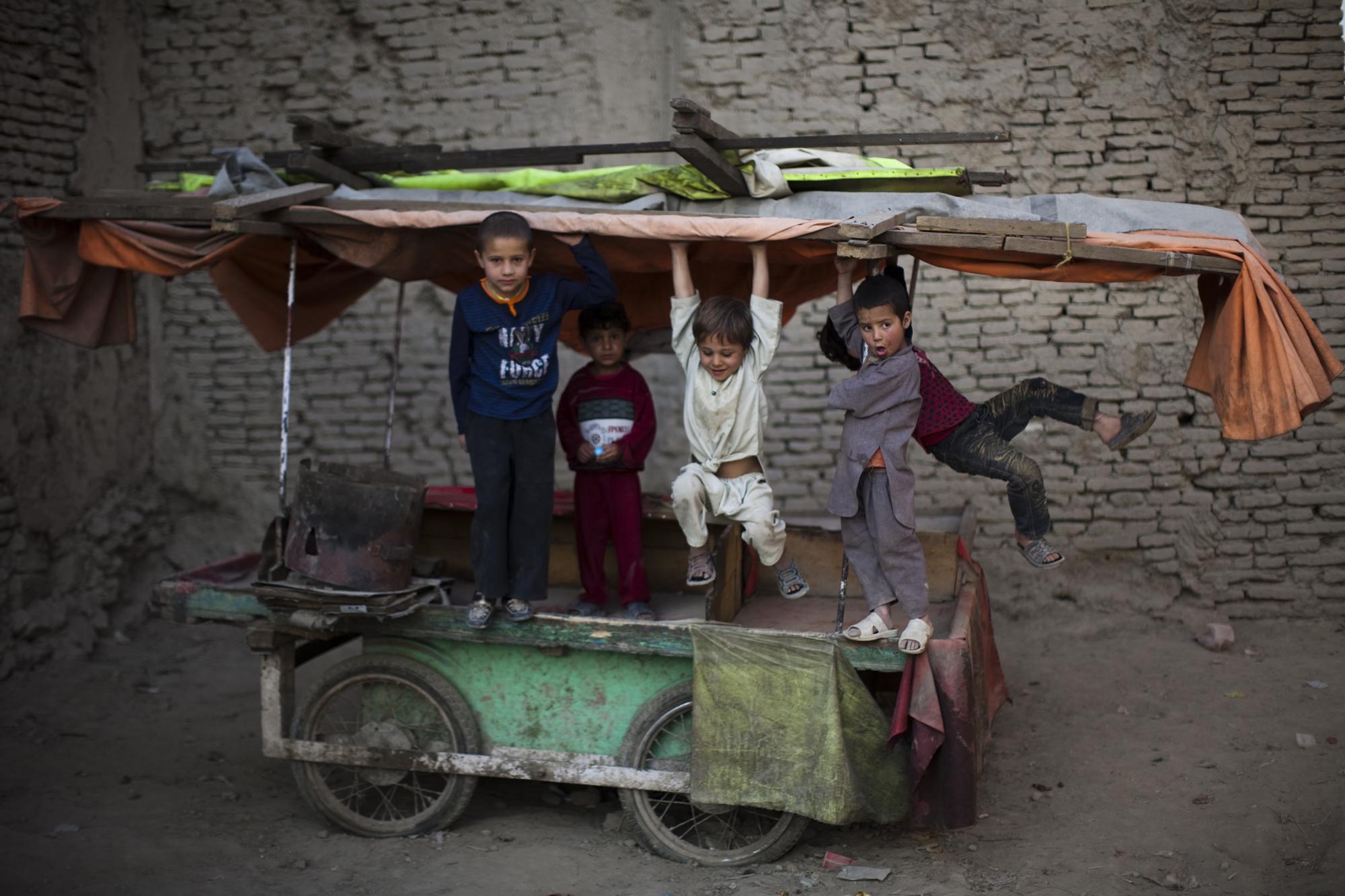 Children play on a market cart, Oct. 31, 2010, in the old part of Kabul, Afghanistan.