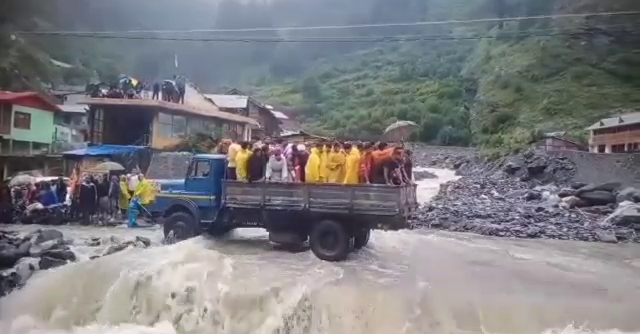 People crossing river on JCB in Uttarkashi