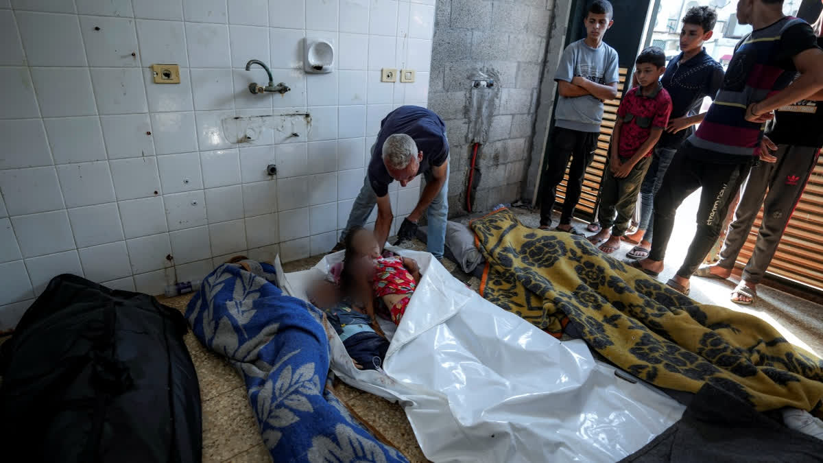 Palestinians check the bodies of their relatives, including children, killed in the Israeli bombardment of the Gaza Strip, at a hospital morgue in Deir al-Balah, Saturday, July 13, 2024.