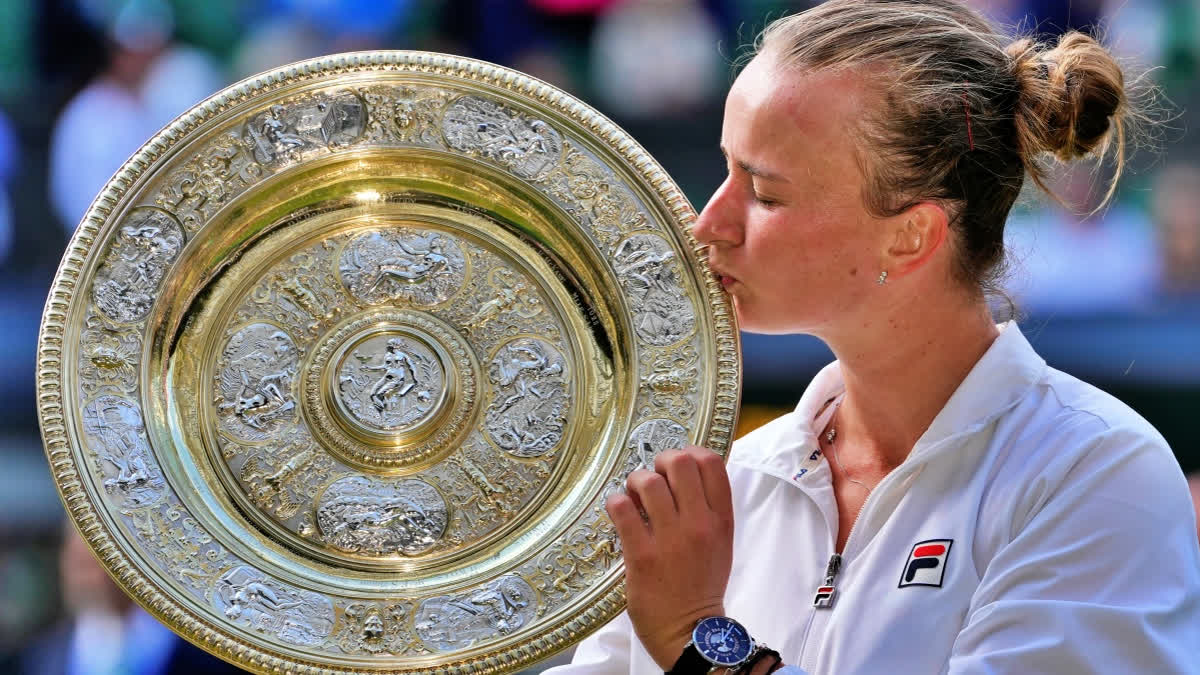 Barbora Krejcikova of the Czech Republic kisses her trophy after defeating Jasmine Paolini of Italy in the women's singles final at the Wimbledon tennis championships in London, Saturday, July 13, 2024.