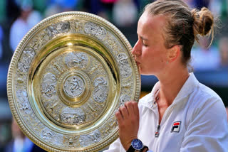 Barbora Krejcikova of the Czech Republic kisses her trophy after defeating Jasmine Paolini of Italy in the women's singles final at the Wimbledon tennis championships in London, Saturday, July 13, 2024.