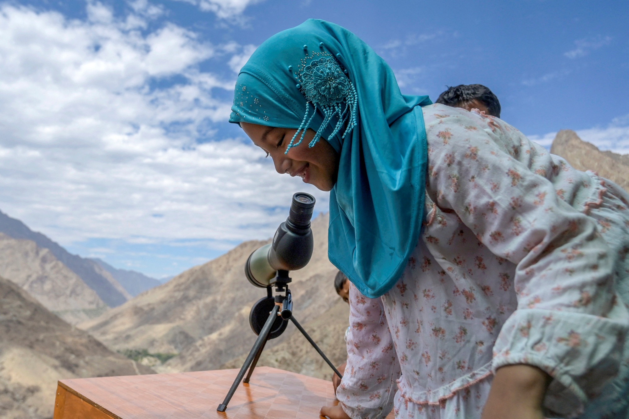 In this photograph taken on July 27, 2024 a girl visits a viewpoint overlooking Pakistan, near Line of Control (LOC) - the border between India and Pakistan, at the Hunderman village in Kargil district.