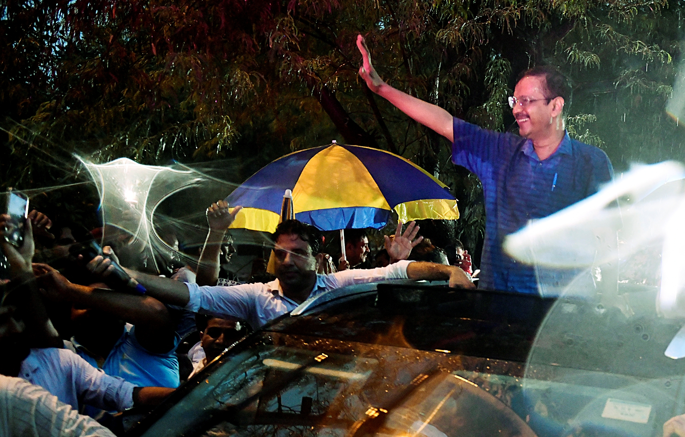 Delhi Chief Minister Arvind Kejriwal waves to AAP workers after walking out of Tihar jail in Delhi