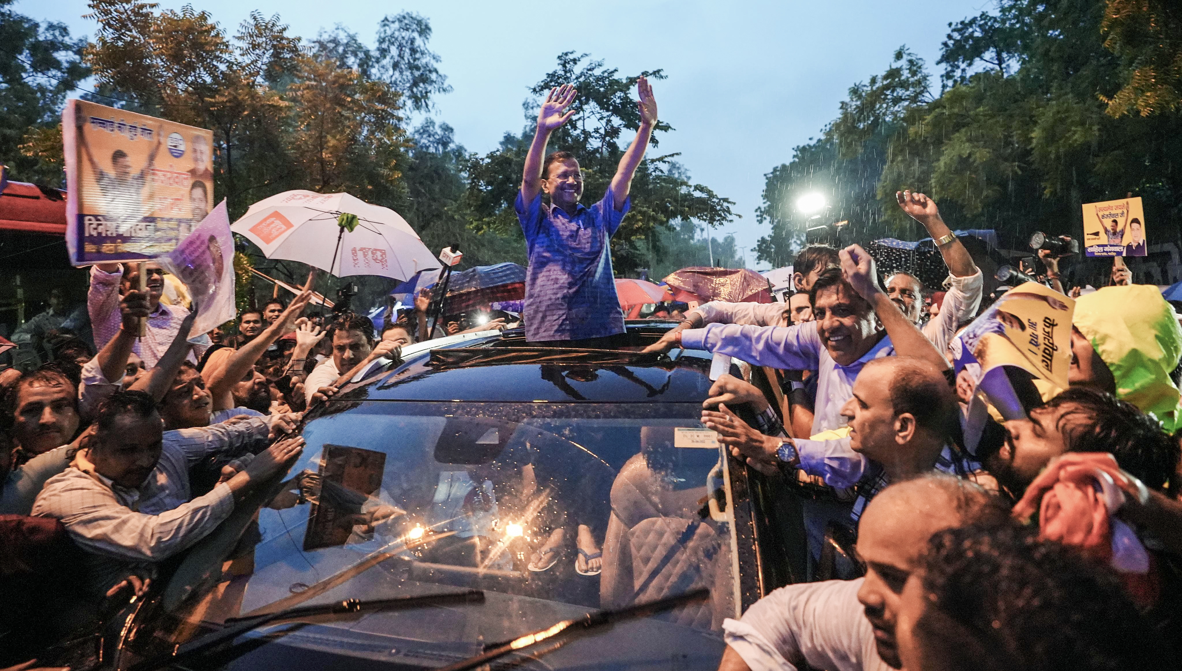 Delhi Chief Minister Arvind Kejriwal waves to AAP workers after walking out of Tihar jail in Delhi