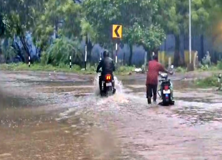 சாலைகளில் தேங்கியுள்ள மழை நீரில் வாகன ஓட்டிகள் சிரமப்பட்டு செல்லும் காட்சி