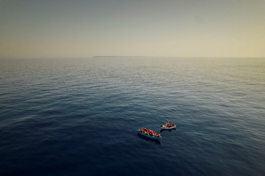 In this Thursday July 29, 2021 file photo, a group thought to be migrants from Tunisia aboard precarious wooden boats wait to be assisted by a team of the Spanish NGO Open Arms, around 20 miles southwest from the Italian island of Lampedusa, in Italian SAR zone. The NGO assisted more than 170 people who arrived next to the Italian island on board six different wooden dinghies, before the Italian authorities took them to land.