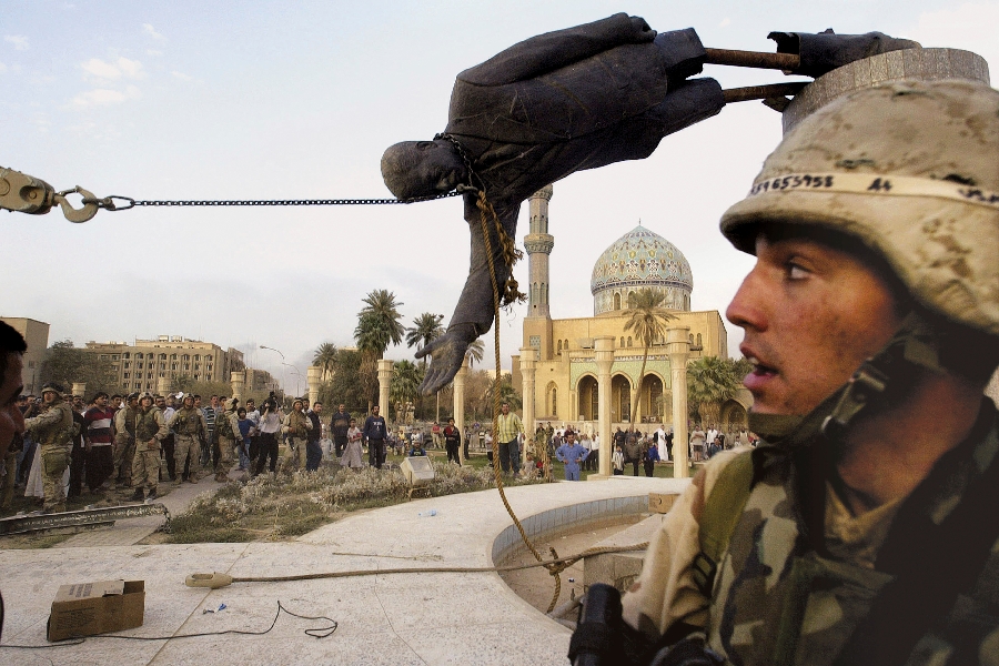 Iraqi civilians and U.S. soldiers pull down a statue of Saddam Hussein in downtown Baghdad, in this April 9, 2003 file photo. The U.S. invaded Iraq on false claims that Hussein was hiding weapons of mass destruction.