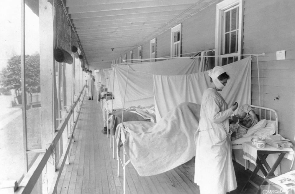 In this November 1918 photo made available by the Library of Congress, a nurse takes the pulse of a patient in the influenza ward of the Walter Reed hospital in Washington. Historians think the pandemic started in Kansas in early 1918, and by winter 1919 the virus had infected a third of the global population and killed at least 50 million people, including 675,000 Americans.