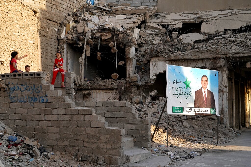 Campaign posters for parliamentary elections are displayed near destroyed buildings from fighting between Iraqi forces and the Islamic State group in Mosul, Iraq, Sunday, Oct. 3, 2021. Iraq on Sunday, Oct. 10, holds its fifth election since the 2003 U.S.-led invasion that toppled Iraqi dictator Saddam Hussein, with most Iraqis longing for real change.