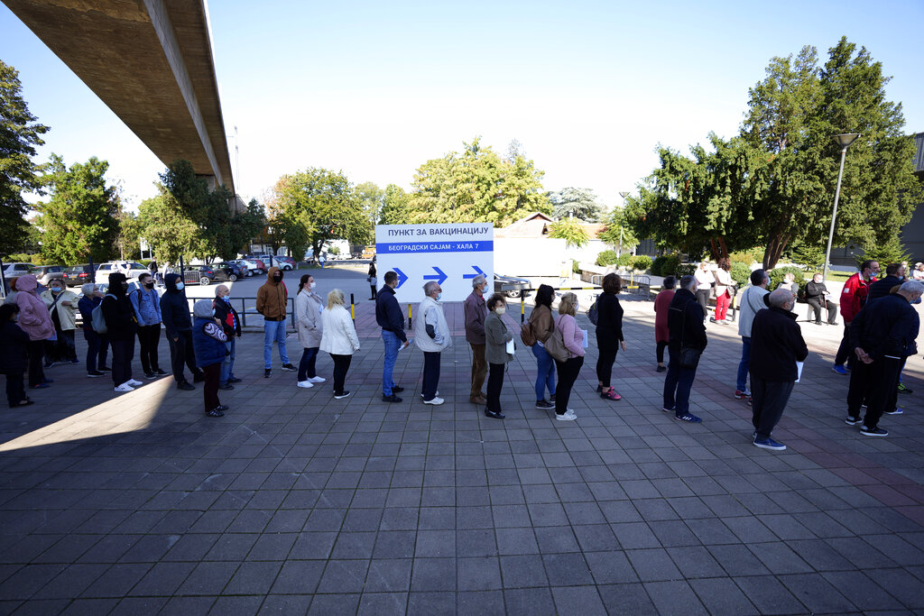 People wait in line to receive a dose of a COVID-19 vaccine at Belgrade Fair makeshift vaccination center in Belgrade, Serbia, Saturday, Oct. 2, 2021.