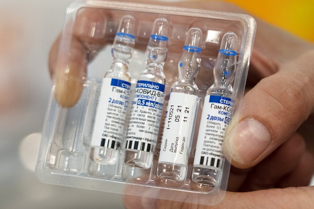 In this July 1, 2021, file photo, a medical worker shows vials with Russia's Sputnik V coronavirus vaccine in a medical room, at a vaccination center in the GUM, State Department store, in Red Square in Moscow, Russia. Russians are flocking to Serbia to receive Western-approved COVID-19 shots. Although Russia has its own vaccine known as Sputnik V, the shot has not been approved by international health authorities.
