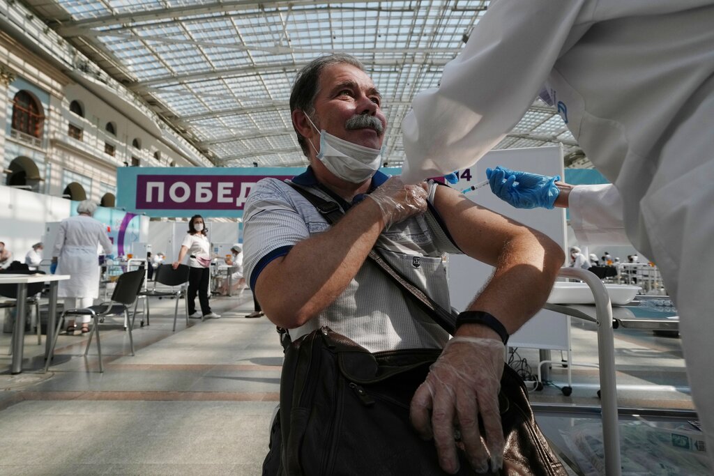 In this July 12, 2021, file photo, a medical worker administers a shot of Russia's Sputnik V coronavirus vaccine at a vaccination center in Gostinny Dvor, a huge exhibition place in Moscow, Russia. Russians are flocking to Serbia to receive Western-approved COVID-19 shots. Although Russia has its own vaccine known as Sputnik V, the shot has not been approved by international health authorities.