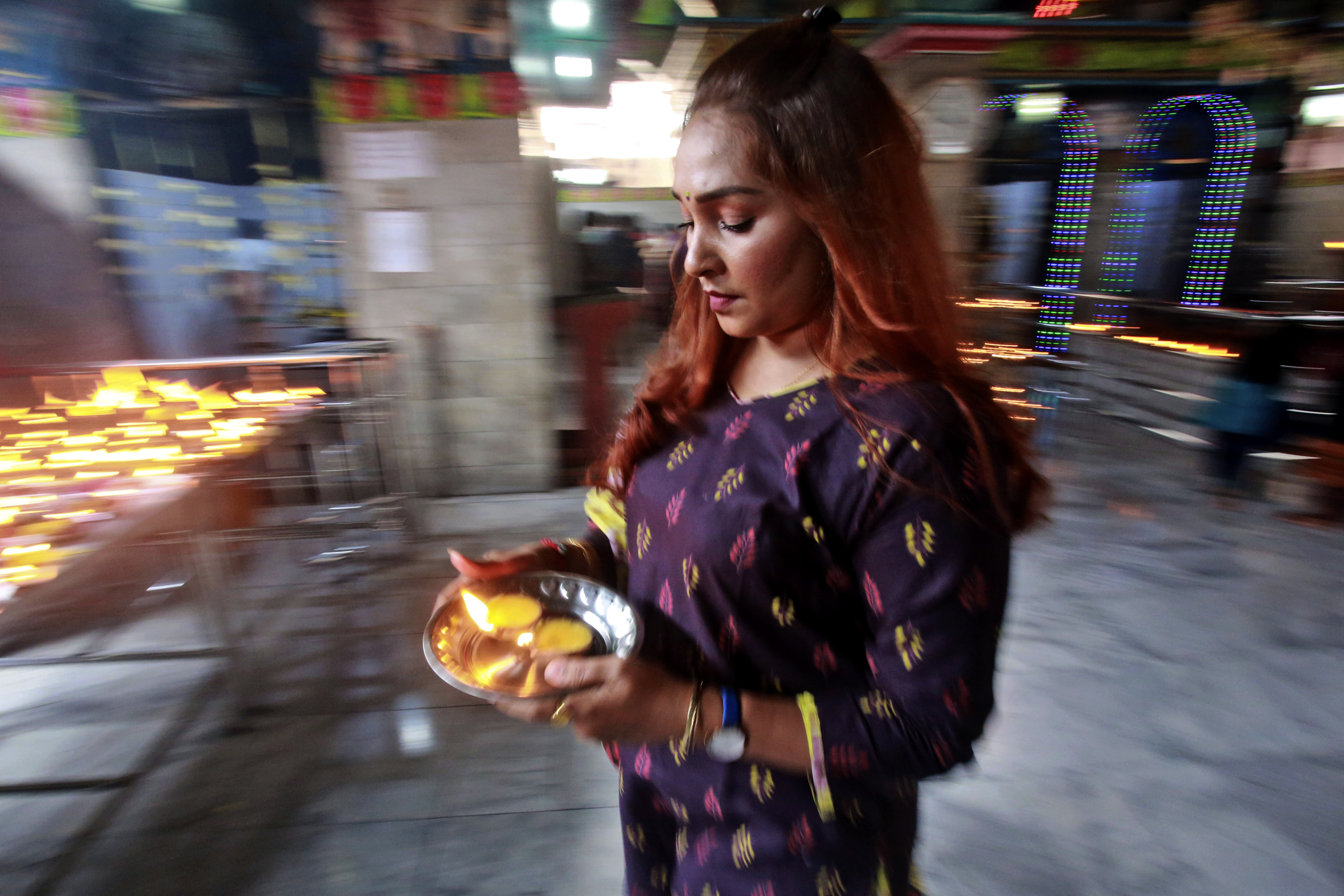 A devotee carries candles during Diwali at the Sri Mariamman Temple