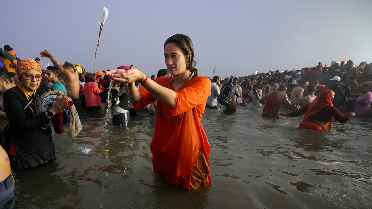 A devotee performs rituals as she takes a holy dip at the Sangam on the occasion of 'Makar Sankranti' festival, during the Maha Kumbh Mela 2025, in Prayagraj, Uttar Pradesh, Tuesday, Jan. 14, 2025.