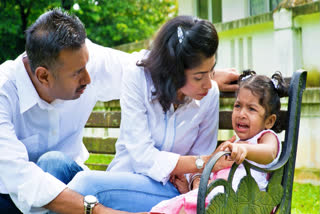 Little girl crying while her parents try to console her