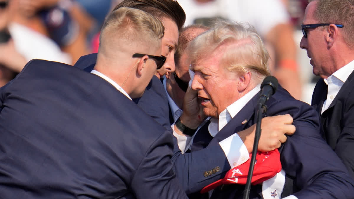 Former US President Donald Trump surround by US Secret Service agents at campaign rally on July 13 in Butler, Pa.