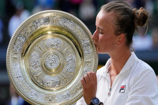 Barbora Krejcikova of the Czech Republic kisses her trophy after defeating Jasmine Paolini of Italy in the women's singles final at the Wimbledon tennis championships in London, Saturday, July 13, 2024.