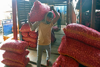 File photo of a labourer carrying a sack of onion