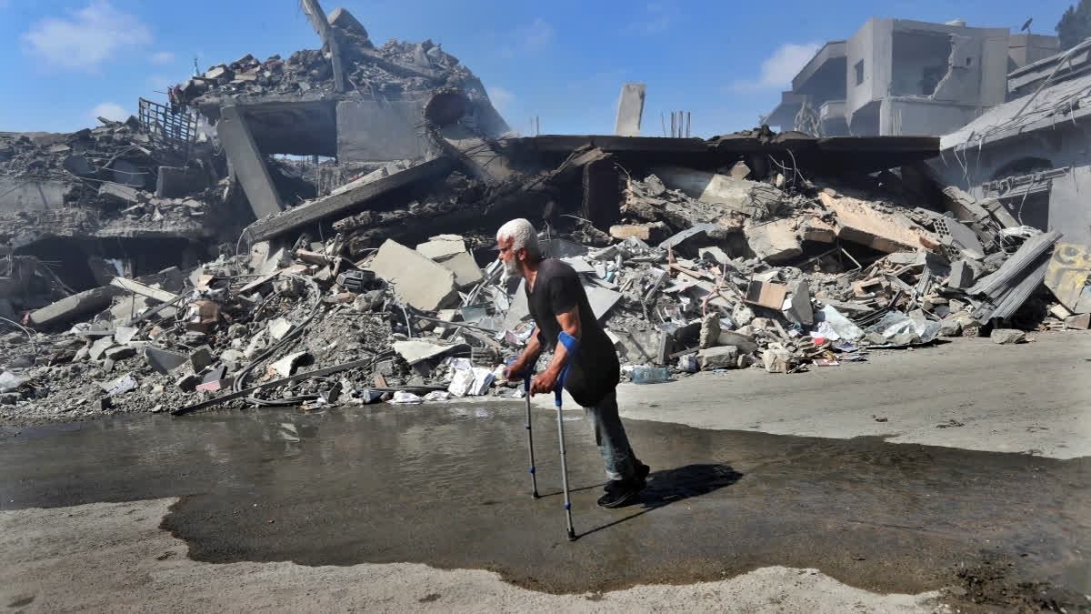 A man walks in front of destroyed buildings on a commercial street that was hit Saturday night by Israeli airstrikes, in Nabatiyeh town, south Lebanon, Sunday, Oct. 13, 2024.