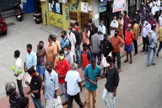 People stand in a long queue to purchase liquor at a Beverages Corporation (Bevco) outlet