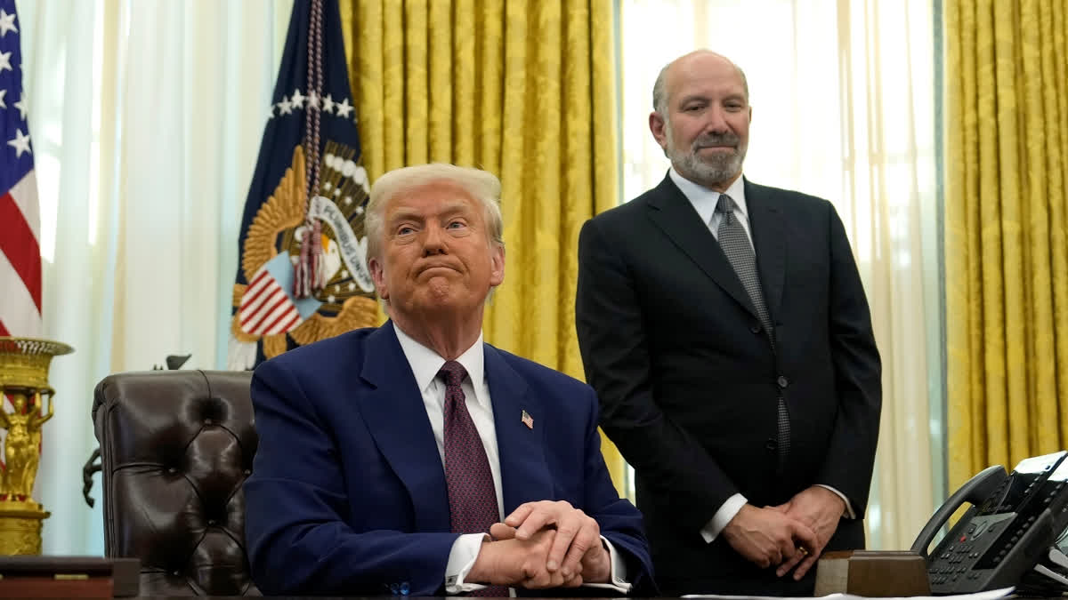 President Donald Trump listens to a question from a reporter as Commerce Secretary nominee Howard Lutnick watches after Trump signed an executive order in the Oval Office of the White House, Thursday, Feb. 13, 2025, in Washington.