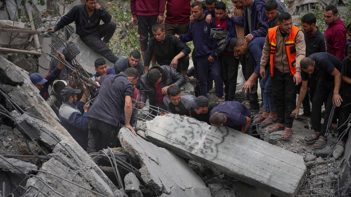 Volunteers and emergency workers try to move a concrete pillar as they search for bodies and survivors from the rubble of the Manoun family's house after it was targeted by an Israeli army strike in Jabalia al-Balad, Gaza City, Sunday, April 13, 2025.