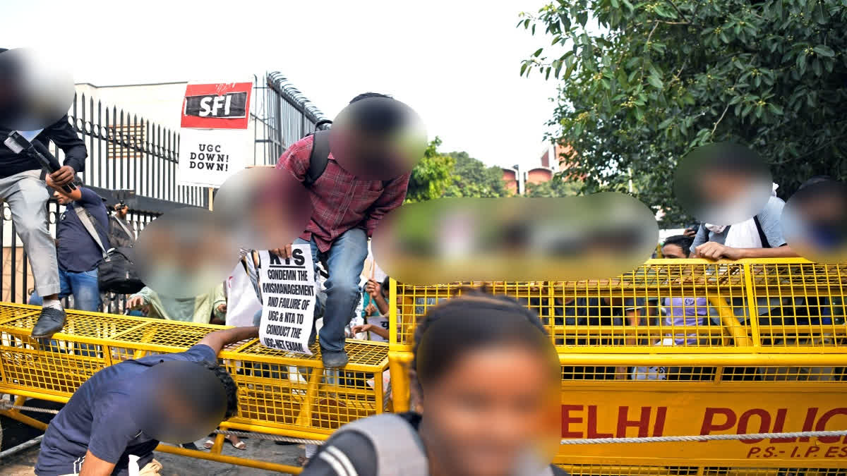 Supporters of Students' Federation of India (SFI) and All India Students Association (AISA) jump over barricades during protest against UGC-NEET exam irregularities in New Delhi