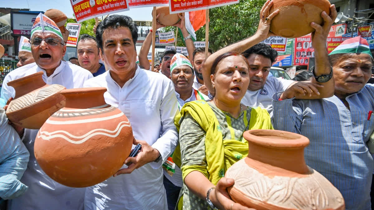 Delhi Congress president Devendra Yadav with party workers carrying earthen pots stage a protest over the water crisis in the national capital on Saturday.