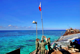 Philippine Marines raise the national flag on the first day of their deployment at the disputed Second Thomas Shoal, locally known as Ayungin Shoal, off the South China Sea, March 30, 2014.