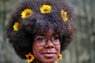 A woman with sunflowers in her hair waits to walk the runway at a fashion show of Afro hairstyles in Havana, Cuba