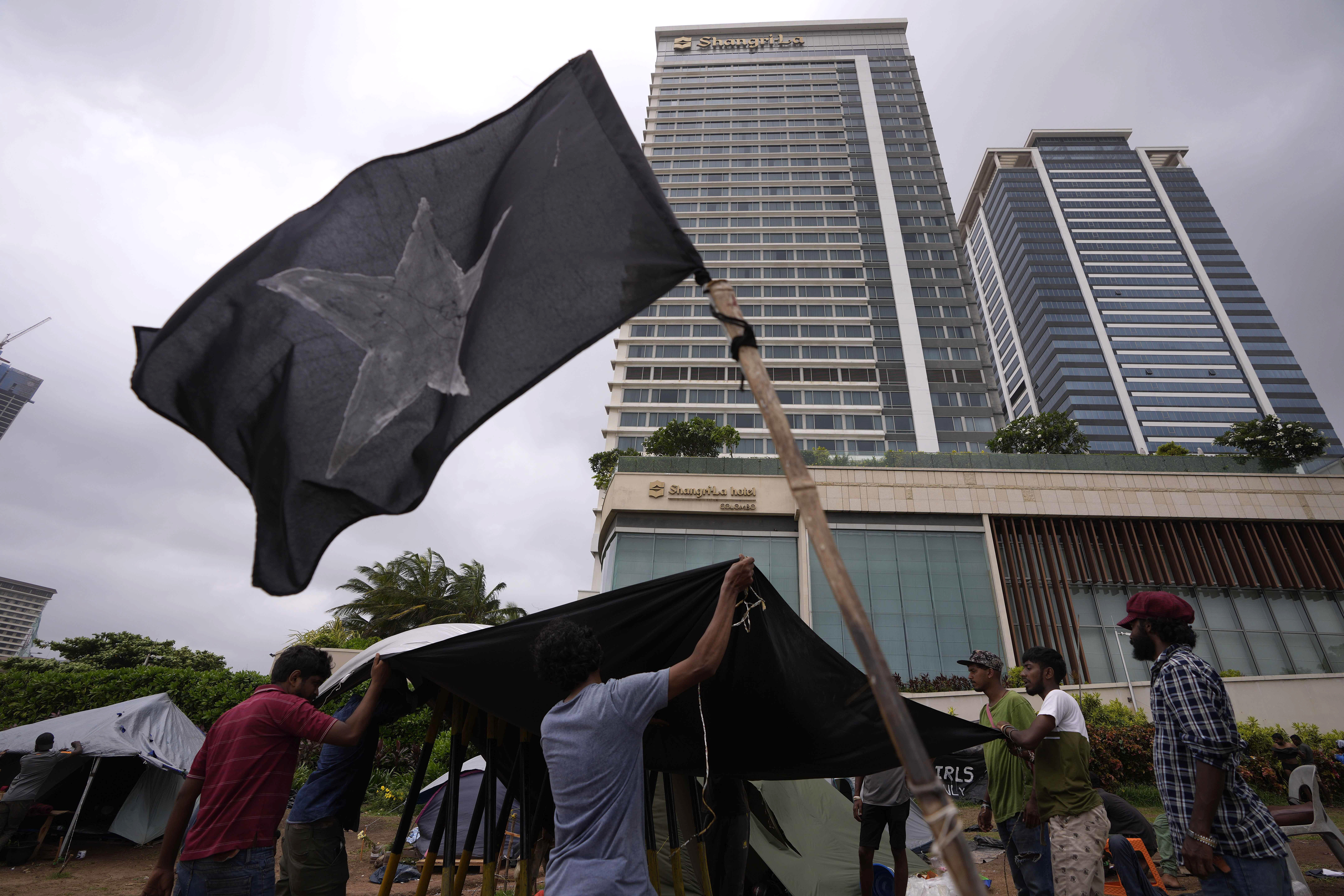 Sri Lankan anti-government protesters mend a tent at the ongoing protest site a day after it was attacked by government supporters in Colombo.